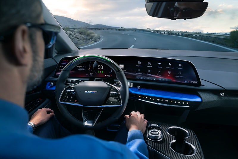 Front View of the 2026 OPTIQ-V Driving Through the Dusk Utilizing its Headlights | Paul Conte Cadillac in Freeport NY